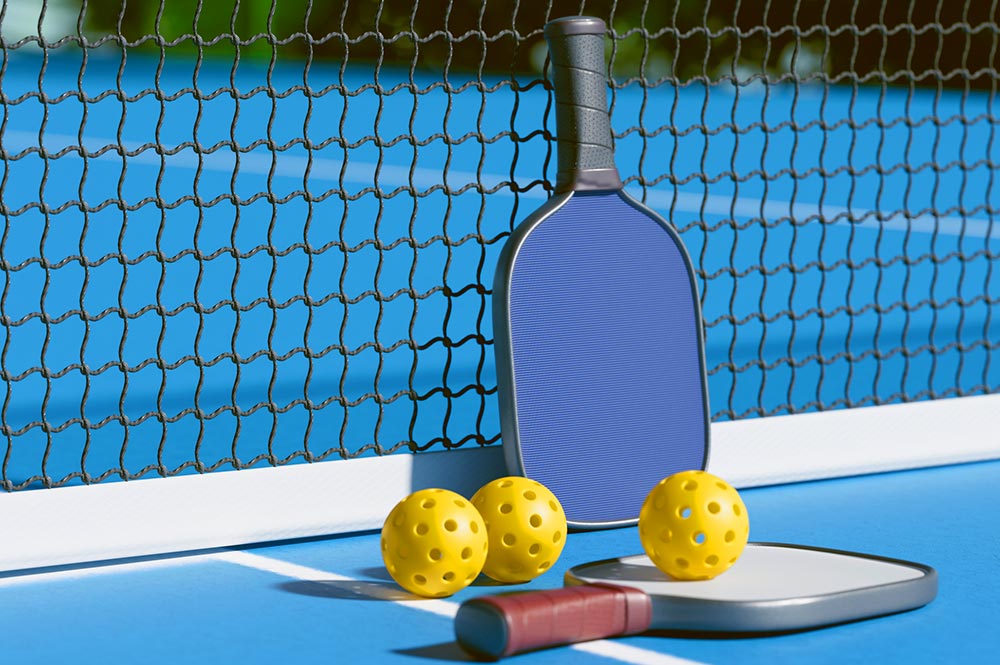A Pickleball Paddle And Balls Resting By The Net